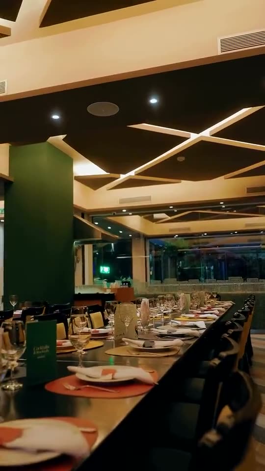Salón de Amazonia Grill, con columnas verdes y plantas